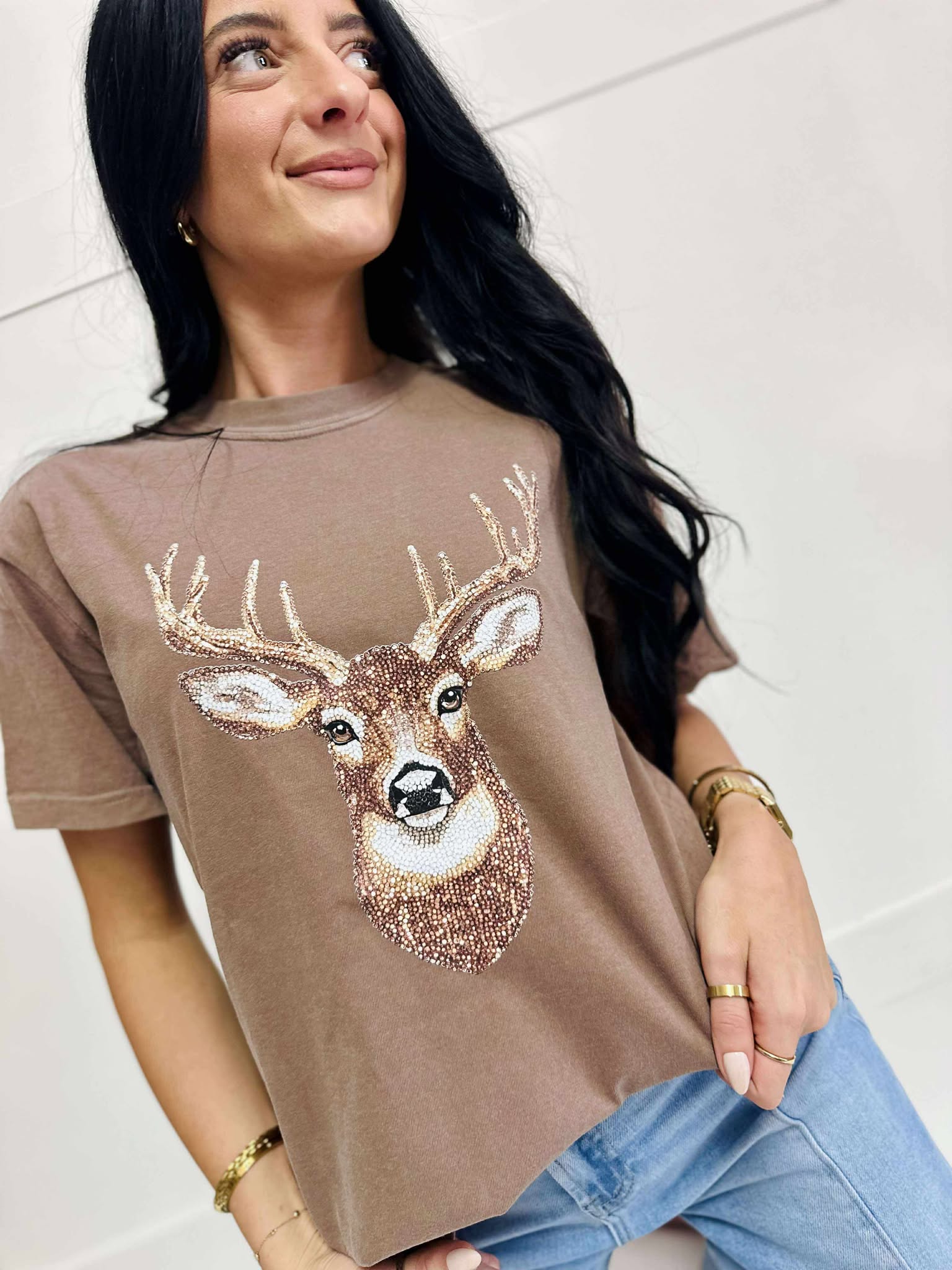 Woman wearing a Espresso t-shirt with a deer graphic design.
