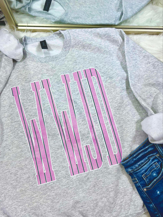 Gray sweatshirt with pink and green stripe WWJD text design on a white surface
